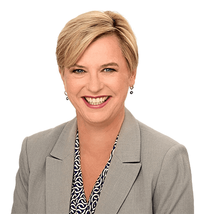 headshot of Tamira Stevensen, head of our business lawyers, in a beige suit with black and white shirt and a bright smile